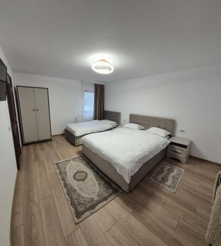 a bedroom with two beds and a wooden floor at Piatra Humorului in Mănăstirea Humorului