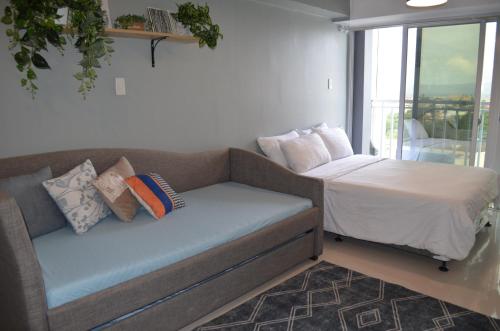 a couch and a bed in a room at Condo Inspiria Beside Abreeza Mall in Davao City