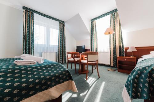 a hotel room with two beds and a table at Komorni Hurka in Cheb