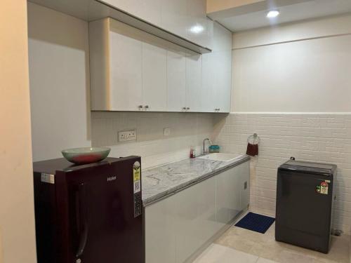 a small kitchen with a sink and a refrigerator at Beruru Homes- 2BHK Apartment near Bengaluru Airport in Devanhalli