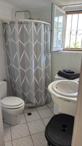 a bathroom with a toilet and a shower curtain at Little Summer Chalet in Saronida