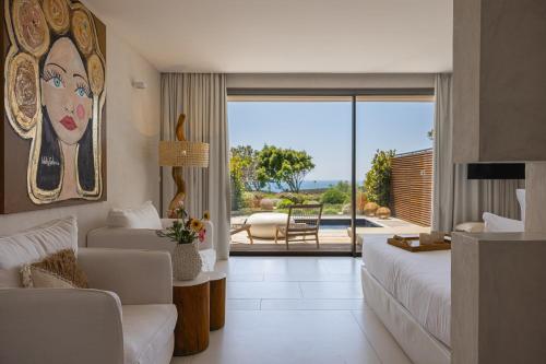a bedroom with a bed and a living room at Hôtel Cala di Greco in Bonifacio
