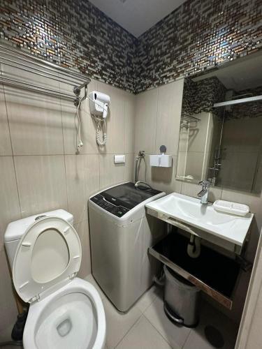 a bathroom with a toilet and a sink at Shell Residences MOA&NAIA by-Sandy in Manila