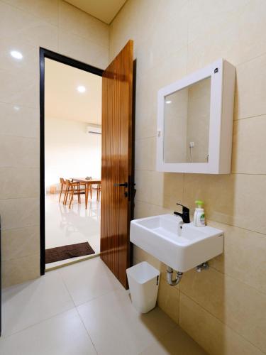 a bathroom with a sink and a mirror and a table at Apatto Bajo in Labuan Bajo