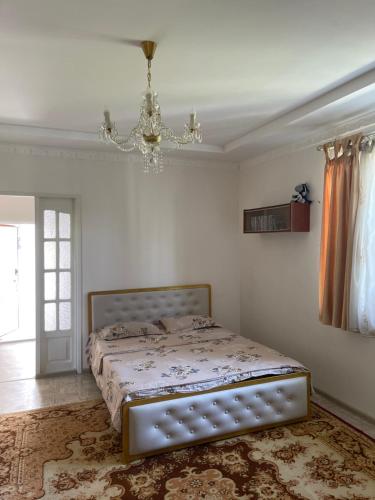 a bedroom with a bed and a chandelier at Жилье на природе с бассейном in Tashkent