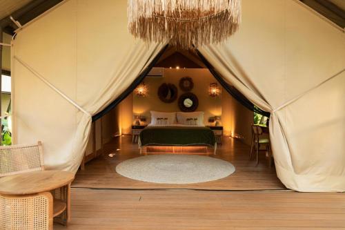 a bedroom with a bed in a tent at Vela Tianyar Boutique Resort - Oceanfront in Tianyar