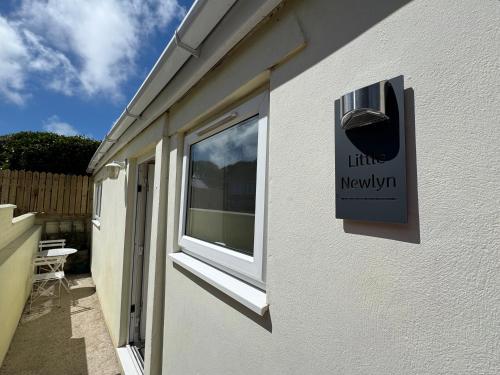 a sign on the side of a building with a window at Little Newlyn in Newlyn