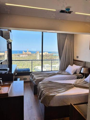a hotel room with two beds and a large window at Montaza City in Alexandria
