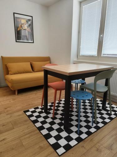 a table and four chairs on a checkered rug in a living room at Studio11 in Medzilaborce
