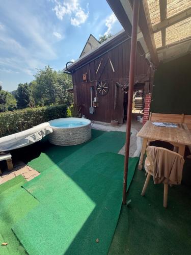 a backyard with a green floor and a hot tub at Pfefferberg Ferienwohnung mit Suite und Junior Suite in Ziegenrück