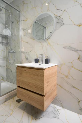 a bathroom with a sink and a mirror at Oropion Rental houses in Néa Palátia