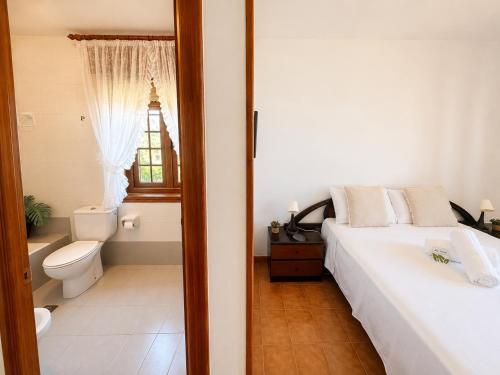 ein Schlafzimmer mit Bett, Toilette und Fenster in der Unterkunft Holibai Mar de Lua, Vila gallega al lado del mar cerca de Baiona in Oia