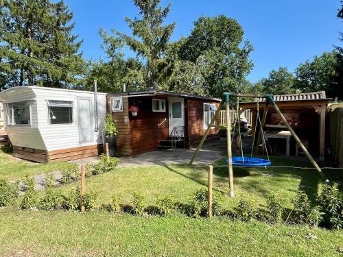 an rv with a swing and a playground at Huisje Eext - De Vos in Eext