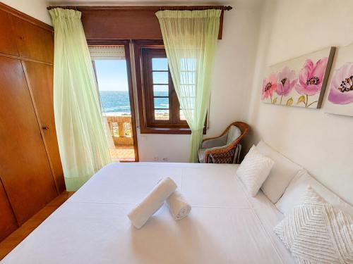 ein Schlafzimmer mit einem Bett, auf dem zwei Handtücher liegen in der Unterkunft Holibai Mar de Lua, Vila gallega al lado del mar cerca de Baiona in Oia