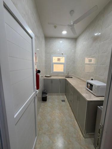 a room with a kitchen with a door and a microwave at حياة صحلنوت in Salalah