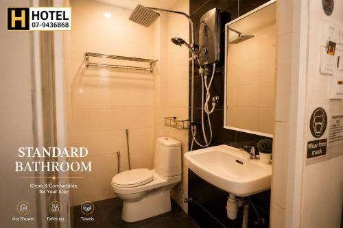 a small bathroom with a toilet and a sink at H Hotel in Segamat