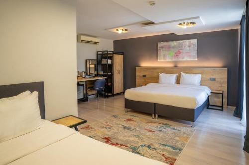 a hotel room with two beds and a desk at Adresin Hotel in Edirne