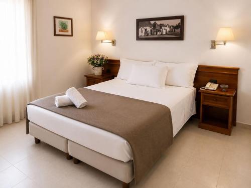 a bedroom with a large bed with a phone on it at Hotel Ramapendula in Alberobello