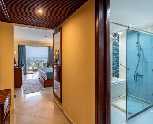 a bathroom with a shower and a glass door at Xperience Sea Breeze Resort in Sharm El Sheikh