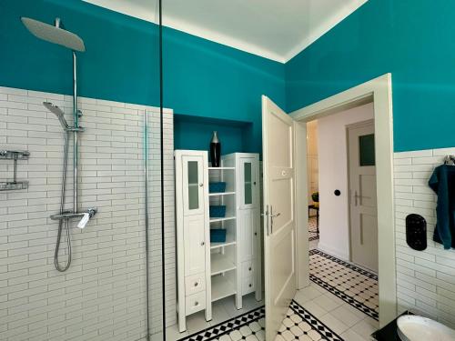 a bathroom with a shower and a blue wall at Stadthaus "Villa Moser" nahe Schloss Esterhazy in Eisenstadt