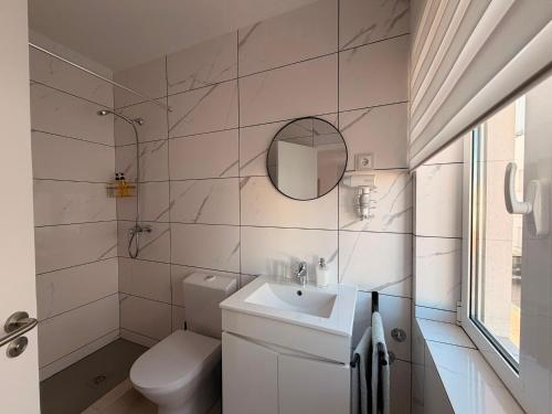 a bathroom with a sink and a toilet and a mirror at Dianamar in Albufeira