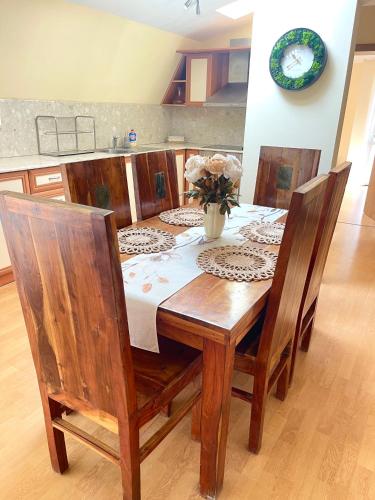 a wooden table with chairs and a vase of flowers on it at Balchik English House in Balchik