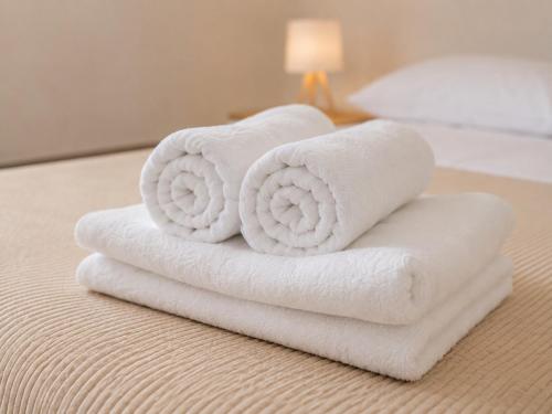 two rolled towels sitting on top of a bed at Palazzo Solera Rooms in Casarano