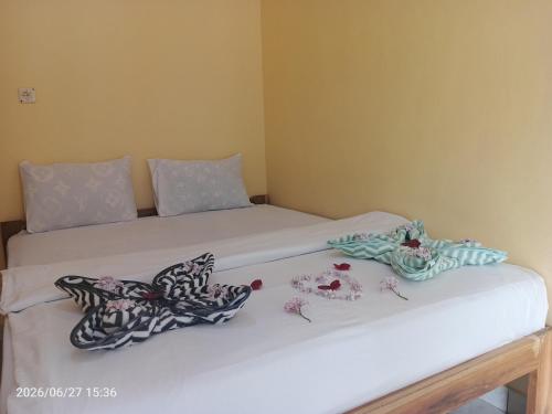 a bedroom with two beds with towels on them at Tange Guest House in Ruteng