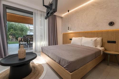 a bedroom with a bed and a table and a window at Dionisos Resort in Pefkochori