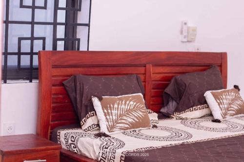 a bed with two pillows on top of it at Mada's House F H L in Abomey-Calavi