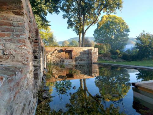 a stone wall with a reflection in a pool of water at Resort Papírna50 in Černý Dŭl