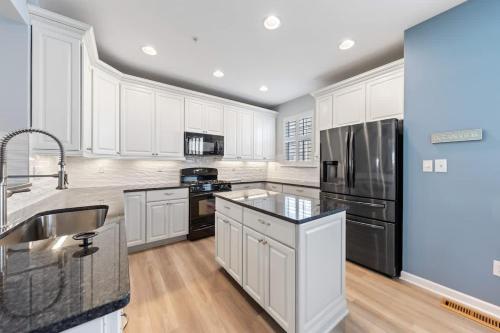 a kitchen with white cabinets and a stainless steel refrigerator at Spacious Resort Villa Near Beach - VBBL in Ocean View