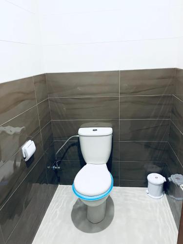 a bathroom with a toilet with a blue seat at Waveside surf house in Tamraght Ou Fella