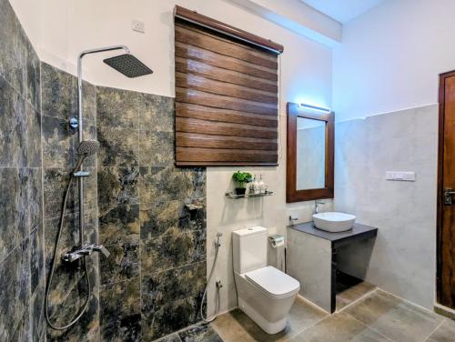 a bathroom with a shower and a toilet and a sink at Ceylan Breeze Beach Resort in Tangalle