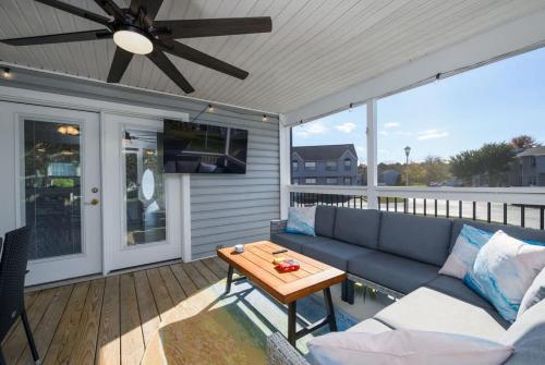 a patio with a couch and a table on a deck at Bethany Beach Retreat with Pool - VTC in Frankford