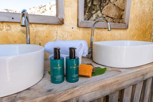 a bathroom counter with two sinks and two bottles of shampoo at Tunu Beach Zanzibar in Kizimkazi