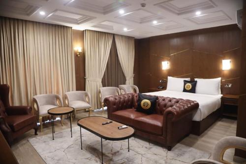 ein Hotelzimmer mit Bett, Sofa und Stühlen in der Unterkunft Taj Signature Boutique Hotel Islamabad by LMY Hospitality in Islamabad