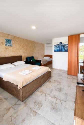 a bedroom with a large bed and a couch at Pensiunea VADU in Vadu