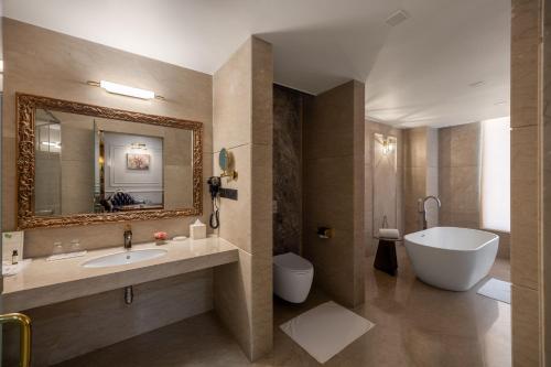 a bathroom with a sink and a tub and a toilet at Blueworld Castles in Kānpur