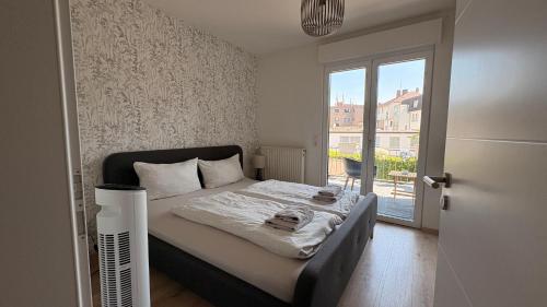 a small bedroom with a bed with a window at BrunnenApart Nova in Bad Oeynhausen