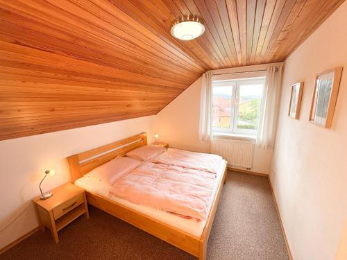a bedroom with a bed with a wooden ceiling at Casa Maika in Frymburk