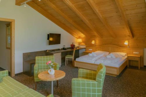 a bedroom with a bed and a table and chairs at Hotel Metzgerwirt in Sankt Veit im Pongau