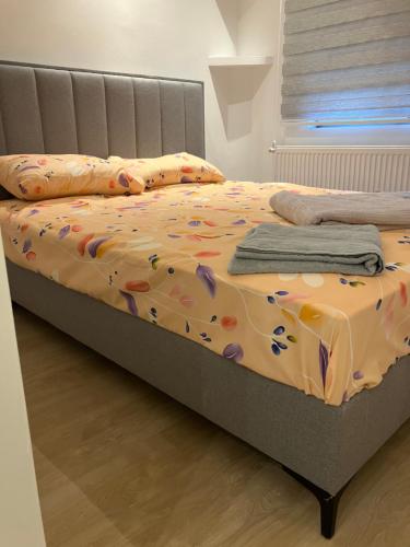 a bed with a blanket and pillows on it at Relax Apratman in Gornji Milanovac