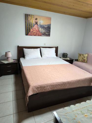 a bedroom with a bed and a painting on the wall at Maria's House in Keramoti