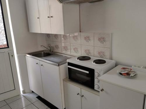 a small kitchen with a stove and a sink at Geni Bay 2 in Lefkada