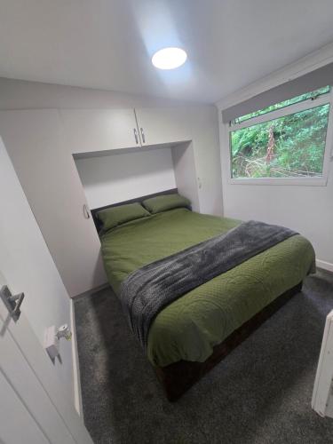 a bedroom with a green bed in a white room at 43 sea valley in Bideford