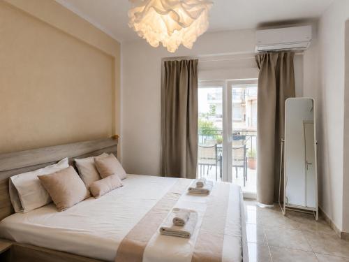 a bedroom with a large bed with a chandelier at Anris & Dianas Dom - In a quiet part of the center in Kallithea Halkidikis