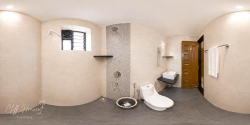 a bathroom with a toilet and a sink at Cliff Heaven in Colva