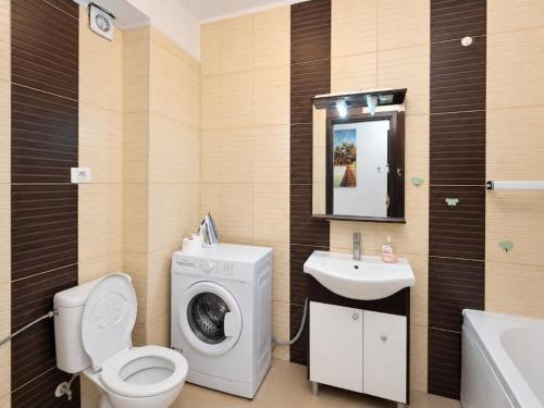 a bathroom with a washing machine and a sink at MAMAIA SAMMERLAND APARTAMENT 3 camere in Mamaia