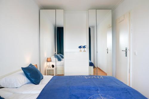 a bedroom with a blue bed and white walls at Ferienwohnung Seeland in Niendorf